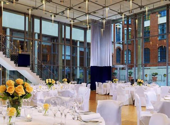 Großer Speisesaal mit riesiger Glasfront, dekoriert mit weißen Hussen an den Tischgarnituren für das Original Kriminal Dinner
