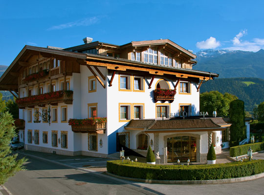 Schönes modernes Haus im Grünen, strahlend blauer Himmel mit den Bergen im Hintergrund