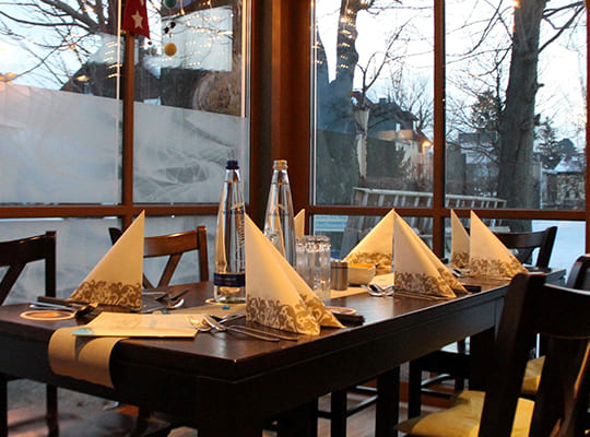 Liebevoll angerichteter Tisch im Restaurant mit Blick auf den verschneiten Garten