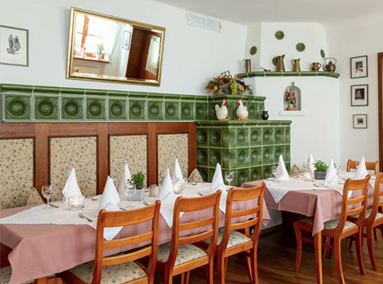 Schön dekorierte Esstische mit Fliesenöfen und schöner Wanddekoration im Restaurant-Bereich.