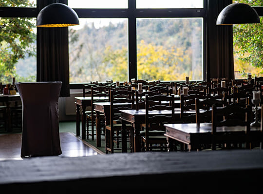Urig modern eingerichteter Speisesaal mit traumhaften Ausblick auf die grünen Wälder um den Burghof herum.