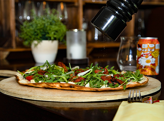 Mediterraner Flammkuchen auf Holzbrett