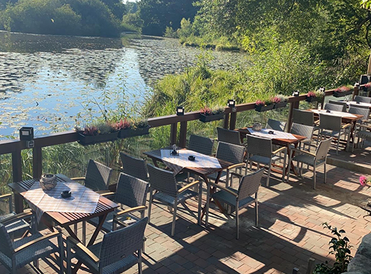 Viele bequeme Sitzgelegenheiten auf der Terrasse des Restaurants mit wundervollem Blick auf den Hasenburger Teich.
