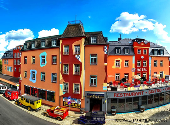 farbenfrohe Außenansicht des Hotels bei hellblauem Himmel