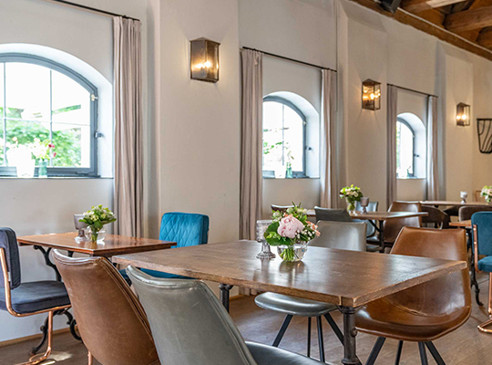 Komplett modernisierter Speisesaal mit gemütlich Stühlen und Rundbogenfenstern