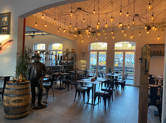 Wundervolle Deckenleuchten erhellen zusammen mit dem Tageslicht den schönen Restaurantbereich mit Blick auf den Bahnhof