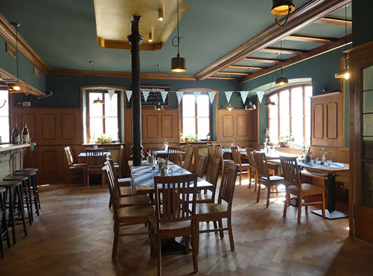 Großer Speisesaal mit hellen, lichtdurchfluteten Fenstern und vielen gemütlichen Sitzgelegenheiten.