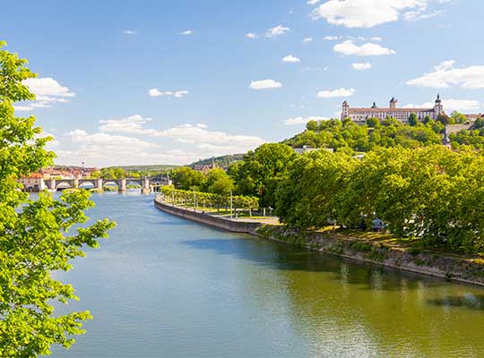 Fluss mit Schloss im Hintergrund, blauer Himmel