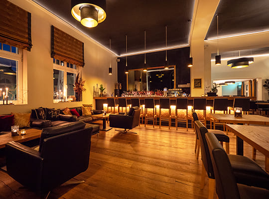 Schön beleuchteter Restaurant- und Bar-Bereich mit vielen Sitzgelegenheiten in am Abend.