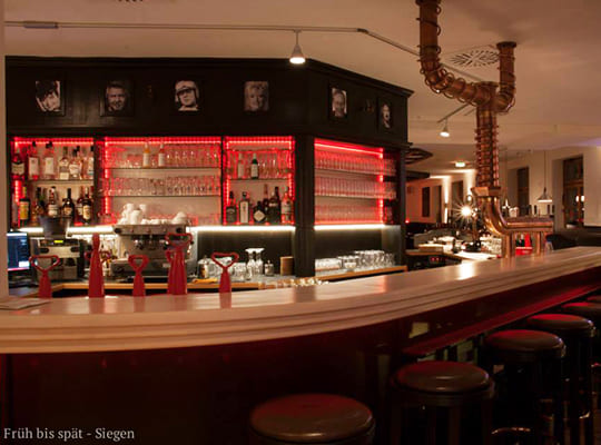 Großer Barbereich mit rot beleuchtetem Bar-Regal