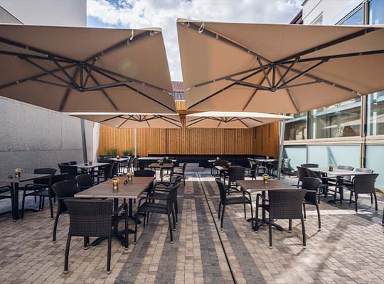 Restaurant-Terrasse mit gemütlichen Sitzmöglichkeiten und großen Sonnenschirmen.