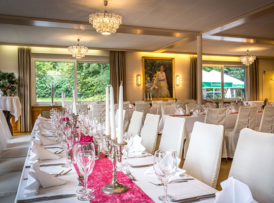 Großes helles Restaurant mit stilvoller Einrichtung in weiß und blumiger Tischdekoration beim Krimidinner Stuttgart
