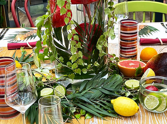 Gedeckter Tisch mit viel Obst und Blättern in ausgefallenem Stil