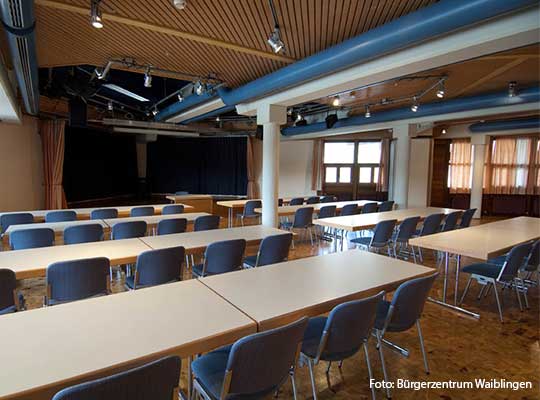 Große Tische, nach vorn ausgerichtet mit blauen Stühlen beim Krimidinner Waiblingen im Bürgerzentrum