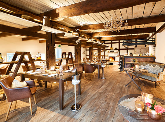 Großer moderner Speisesaal eingerichtet in urigem Holzstyle und schönem Steinofen.