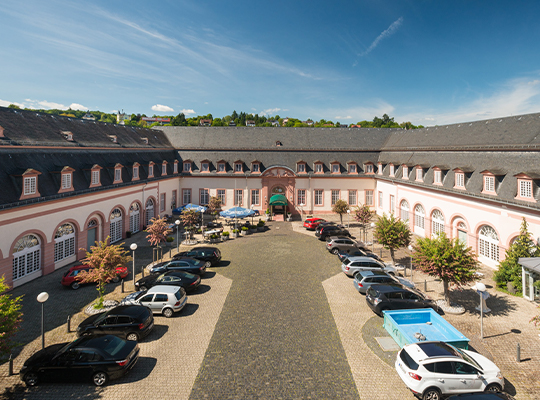 Außenansicht des Schlosshotel Weilburg mit großem Parkplatz