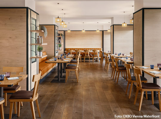 Innenansicht des OXBO Vienna Waterfronts mit gedeckten Tischen